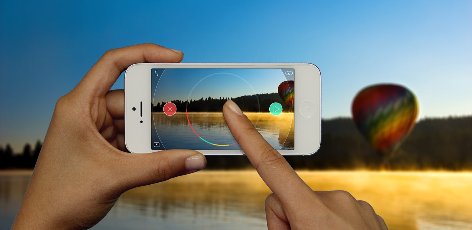 A hand holding an iPhone framing a sunlit lake with a hot-air balloon — Spark Camera's gesture-led recording UI overlaid on the scene.